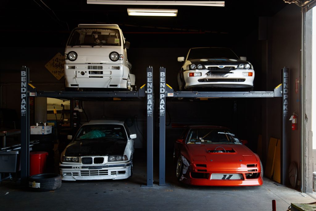 About the Group A collection of modified sports cars on a mechanical garage lift in Compton, CA.